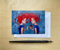 Kunstpostkarte "Rote Zwillinge" – Magische Illustration von zwei Frauen mit flammendem Haar, ideal als Geschenk, Grußkarte oder Wanddeko.