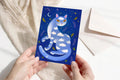 Traumkatze im Nachthimmel – Postkarte A6, Kunstdruck, Blaue Katze mit Wolken & Sternen, Magische Tierillustration, Acrylbild